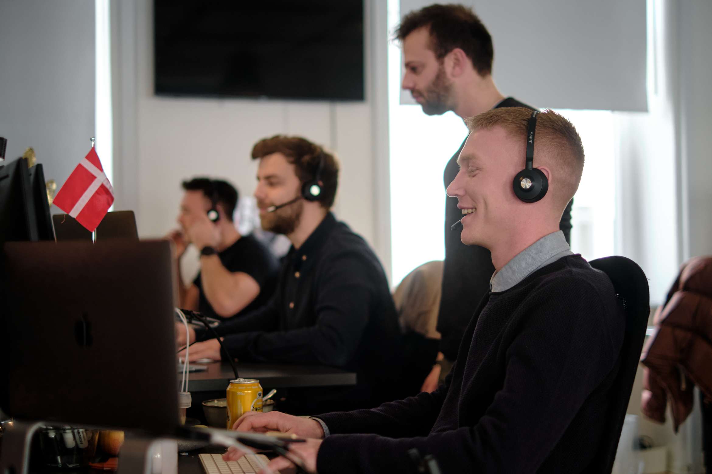 smiling employees at clerk.io with headset on