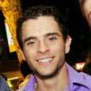 Photo of a man smiling looking at the camera.